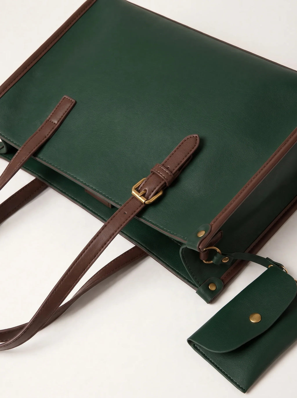 Close-up of adjustable brown vegan leather strap and gold buckle on green tote bag