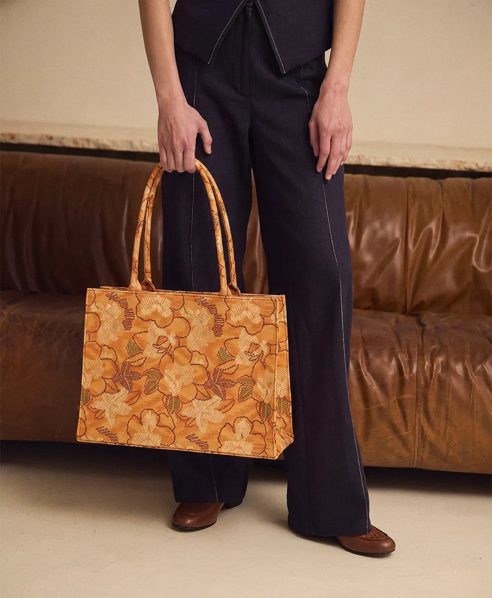 A person holding a large mustard yellow tote bag for women