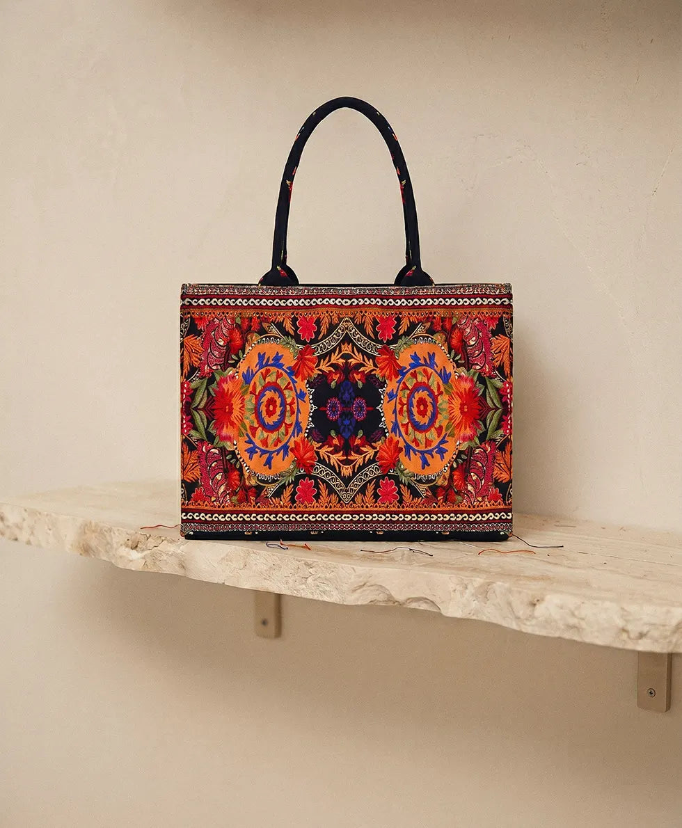 Mirrored ethnic medallion embroidery in red, orange, and blue on black canvas tote
