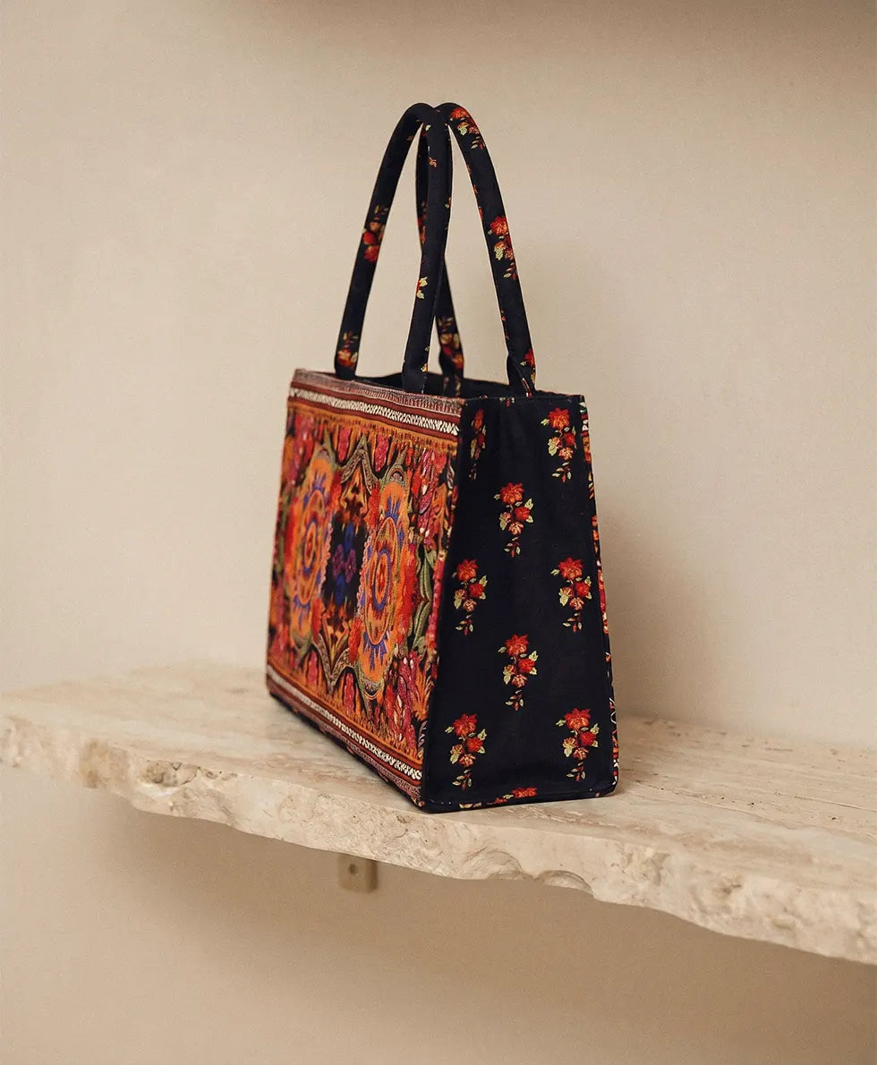 Side view of black embroidered canvas tote bag showing 4 inch depth