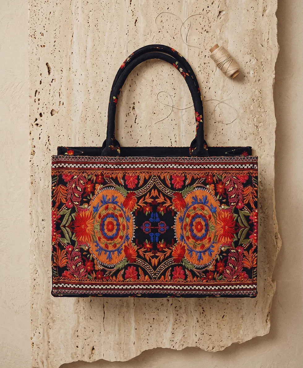 Front view of black canvas tote bag with gold sequin border