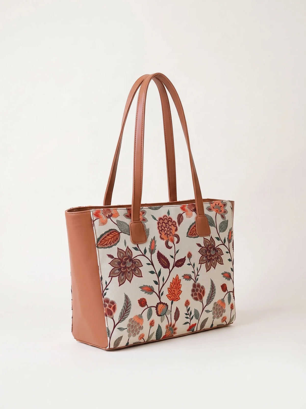 Close up of floral embroidery in rust and olive on beige canvas tote