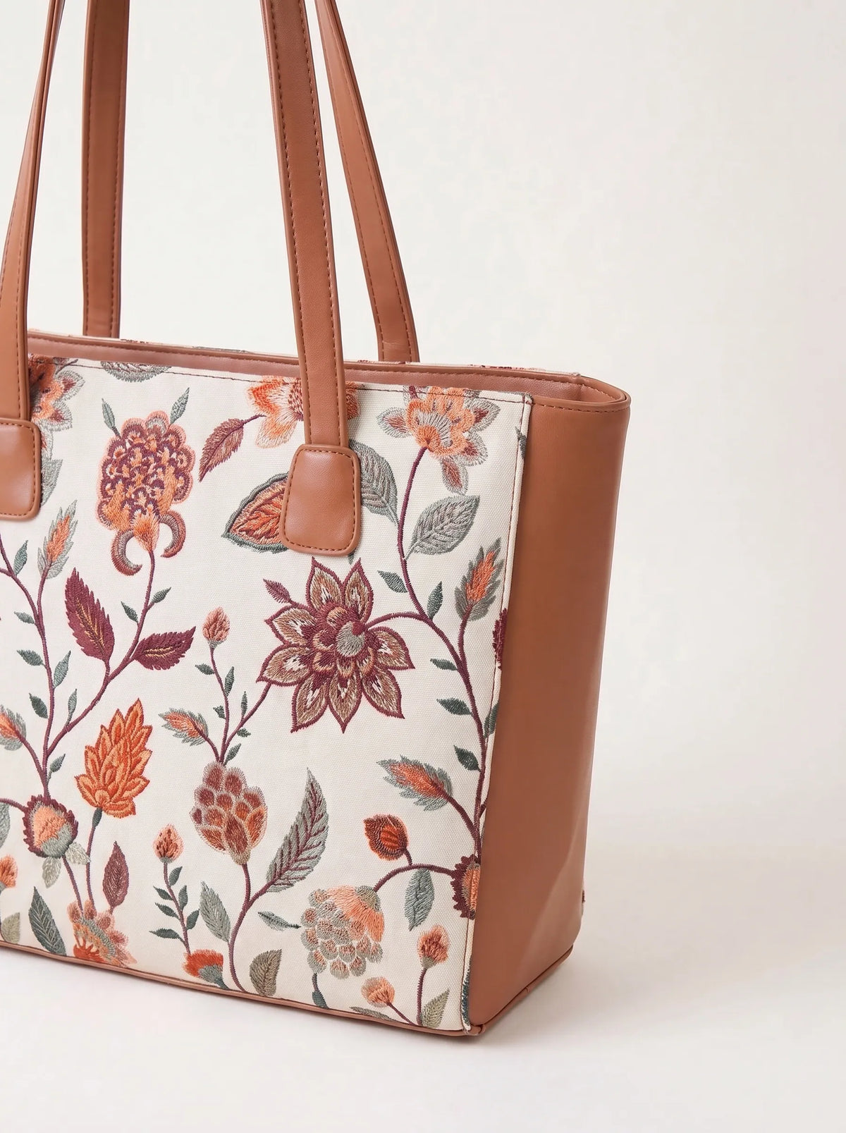 Tan pu leather handles and trim on embroidered canvas tote bag